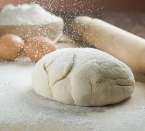 چگونه بفهمیم ورز دادن خمیر نان کافی است؟ -ورز دادن خمیر نان را به‌درستی یاد بگیرید؛ از مدت زمان ورز دادن با دست و دستگاه خمیرگیر تا روش صحیح، نشانه‌های آماده شدن خمیر و اشتباهات رایج.
